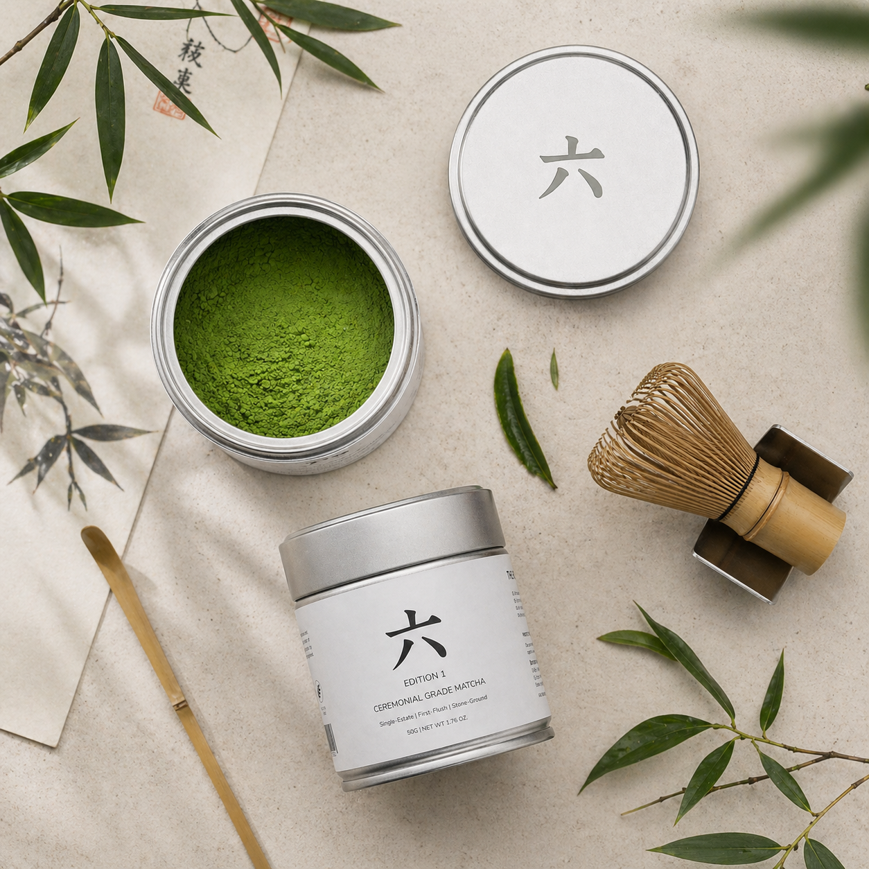 Matcha green tea powder in a container with a whisk and leaves on a light background
