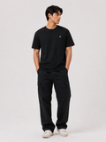 Full body view of a male model wearing the BLACK 6SENSE by ROKURA oversized t-shirt with relaxed black cargo trousers.
